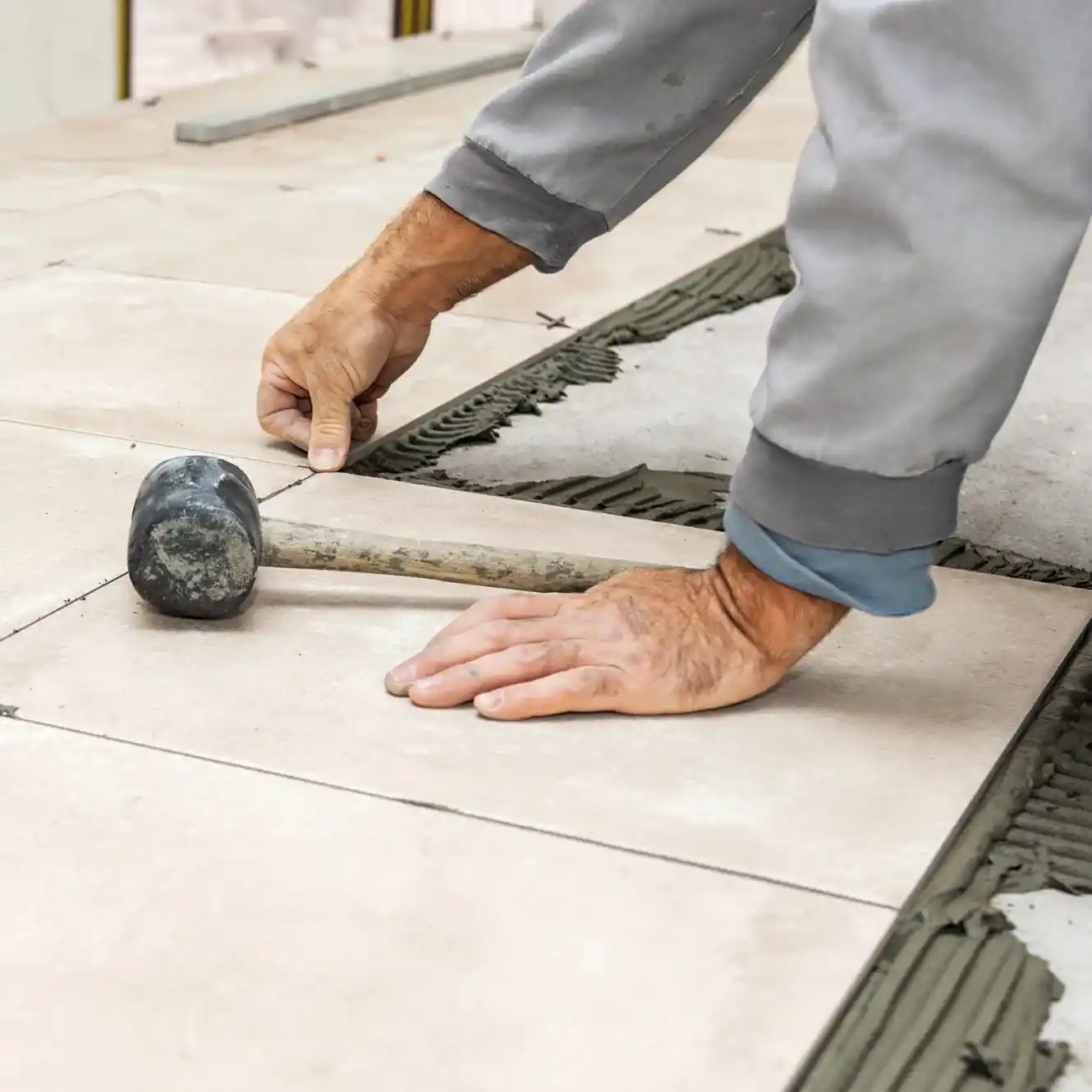 Expert Tile Installation – Seamless and Long-Lasting Finish Skilled worker carefully placing tiles for a smooth and durable surface